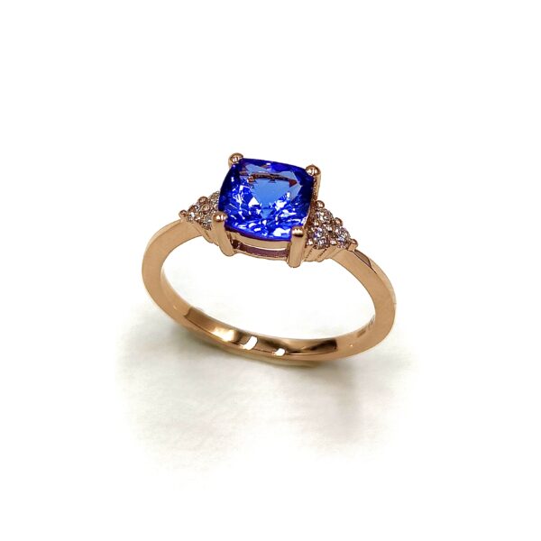 bague en or rose avec une tanzanite sertie 4 griffes et 3 diamants disposés en triangle de chaque coté